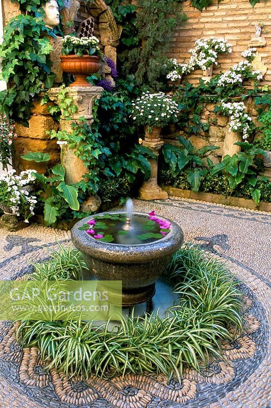 Fontaine avec plantation circulaire et mosaïques dans le jardin de la cour, Cordoue en Espagne