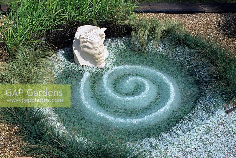 Spirale de copeaux de verre recyclé dans une piscine peu profonde. Toujours de l'eau et des rêves.