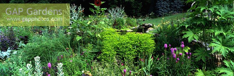Parterre de fleurs avec Euphorbia stricta 'Gold Foam', Helianthus annuus et auto semeur - Pond Garden, Chanticleer Garden, Wayne, Pennsylvanie, USA.