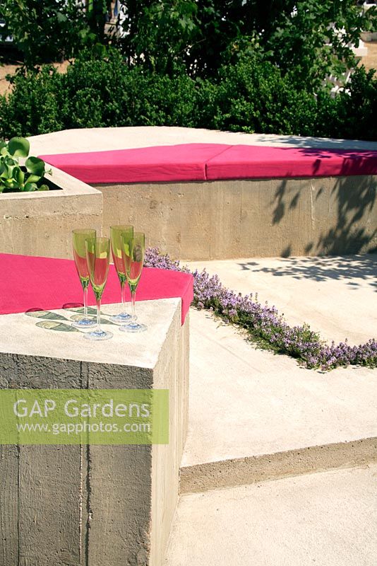 Sièges modernes avec des coussins roses dans le jardin du conglomérat abstrait Hampton Court FS