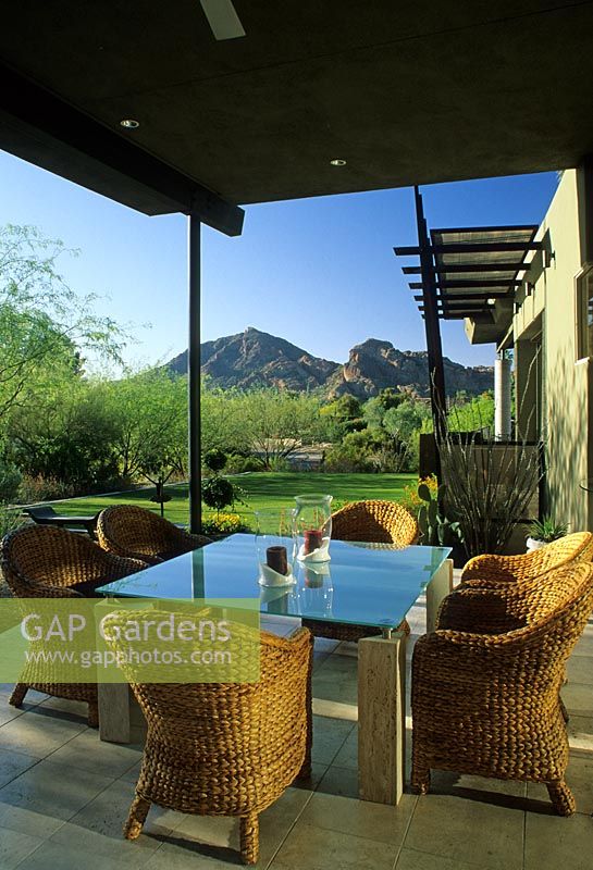 Coin salon sous auvent avec vue sur les montagnes avec des meubles en osier - Le jardin Kotoske, Phoenix, Arizona