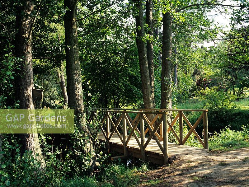Pont en bois dans le jardin d'eau des bois - Moorlands, Sussex