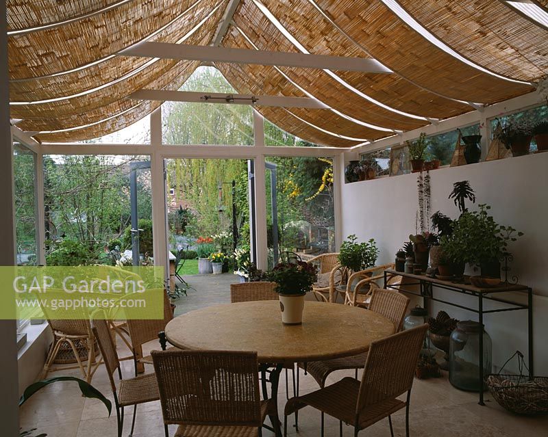 Vue de l'intérieur de la véranda avec stores d'ombrage sur jardin, Design Lisette Pleasance