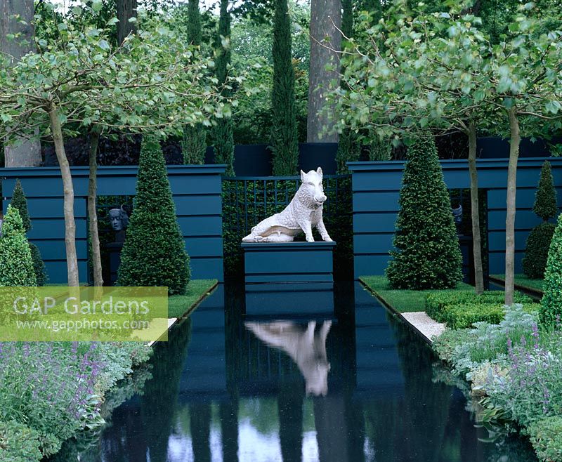 Canal d'eau rectangulaire avec socle et sculpture de sanglier entouré d'ifs topiaires et de Platanus acerifolia - Sculpture de Christie dans le jardin, Chelsea FS