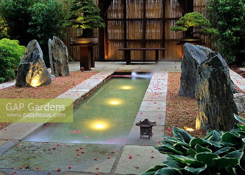 Jardin japonais montrant une longue piscine avec des lumières sous-marines