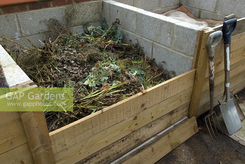 Compost organique dans une baie spécialement conçue, montrant des panneaux de retenue amovibles pour l'accès
