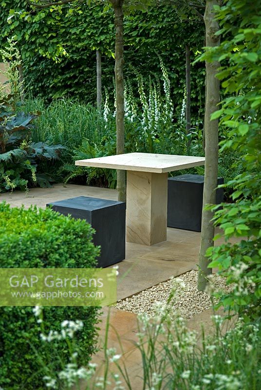 Des sièges et une table modernes dans un coin calme d'un jardin ombragé, The Reflective Garden Sponsor - Ruffer LLP - RHS Chelsea Flower Show 2008
