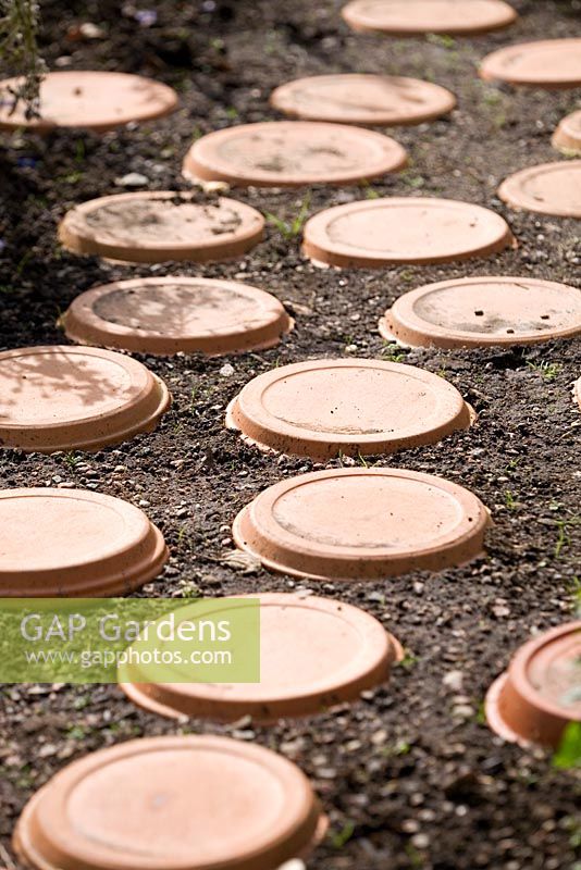 Soucoupes en terre cuite utilisées comme tremplins dans le jardin des enfants - Maja's Garden, Sofiero, Suède
