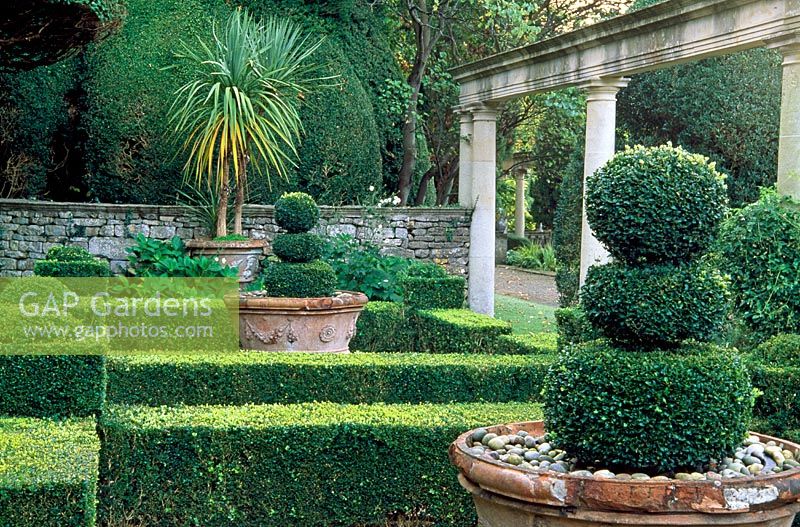 À côté de la Casita est un jardin formel de haies de buis encadrant des pots d'une villa près de Sienne - Iford Manor, Bradford-on-Avon, Wiltshire