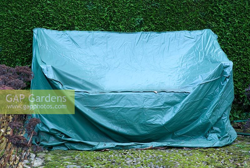 Banc de jardin avec un couvercle de protection vert résistant aux intempéries