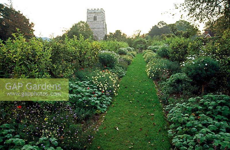 Promenade de l'église recouverte d'Antirrhinum 'Liberty Crimson', d'Argyranthemum 'Vanilla Ripple', de Pelargoniums et de Felicia - Cranborne Manor Garden, Cranborne, Dorset