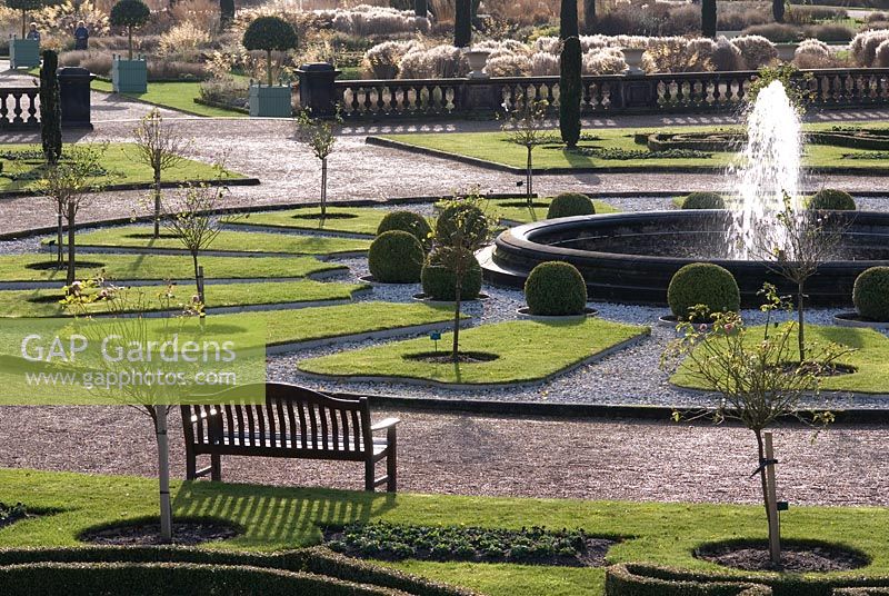 La partie supérieure des jardins italiens formels avec des sphères de boîte, des parterres de fleurs et des roses standard entourant une piscine circulaire avec jet d'eau - Trentham Gardens, Staffordshire