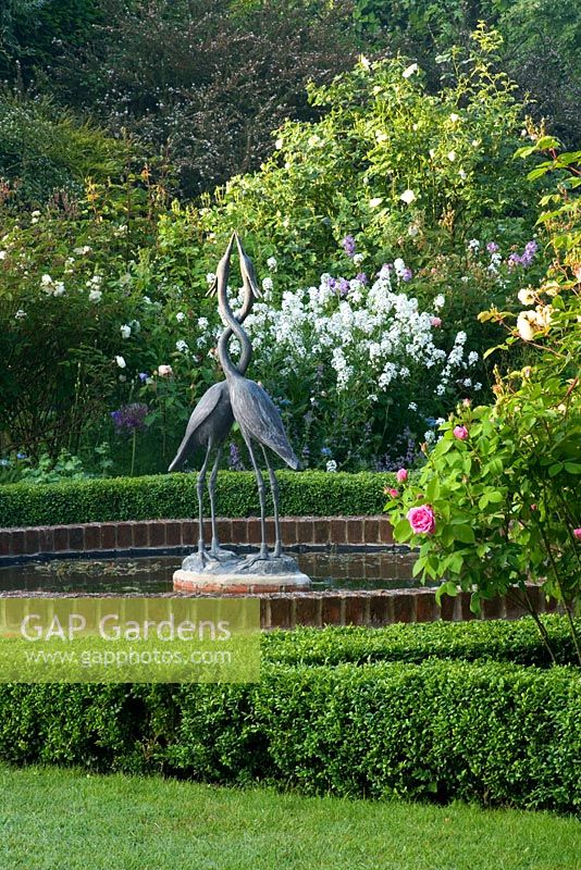 Piscine de nénuphars avec sculpture de hérons dans la roseraie - Mariners Garden, Berkshire