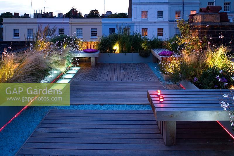 Terrasse en terrasse la nuit avec éclairage LED rose et blanc et gravier de verre bleu - Roof Garden, Holland Park, Londres