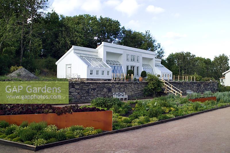 Jardin potager contemporain par le jardinier en chef, Joakim Seiler, sous de grands murs en pierre avec serre nouvellement recréée - Gunnebo Slott, Suède