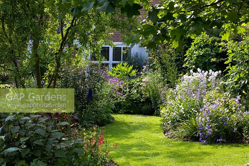 Regardant le jardin vers la maison, courbant la pelouse et les parterres de fleurs - Eldenhurst