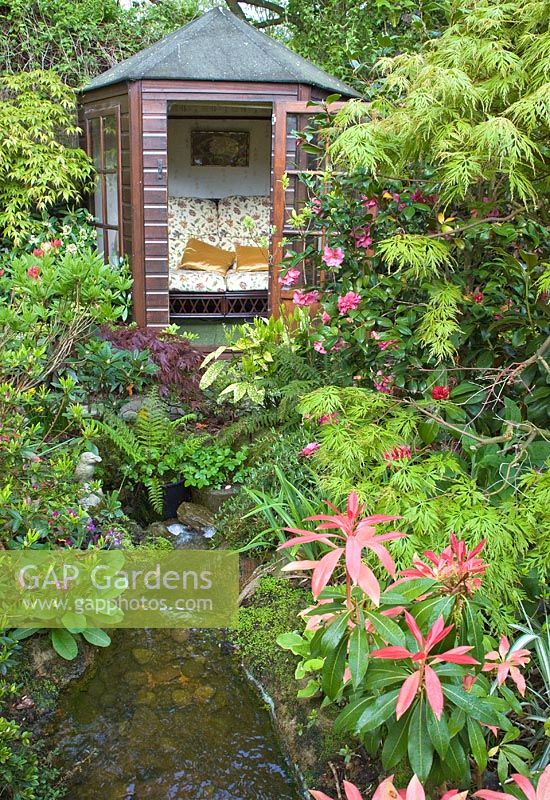 Summerhouse avec Acers matures et arbustes avec ruisseau au jardin Four Seasons NGS, Staffordshire