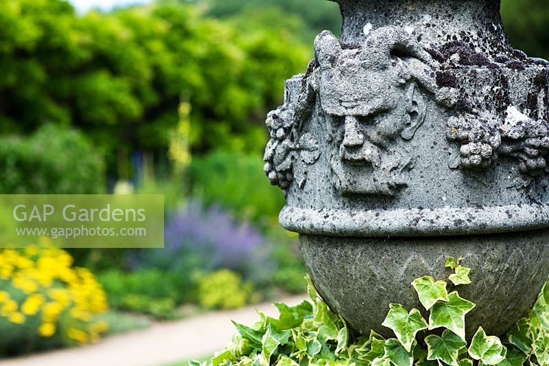 Pan face sur une urne en pierre à Waterperry Gardens, Oxfordshire, Angleterre