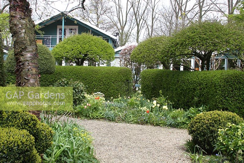 Le Teagarden est une combinaison de jardin modèle, boutique de jardin et salon de thé à Weesp. Route en gravier entourée de parterres de fleurs.