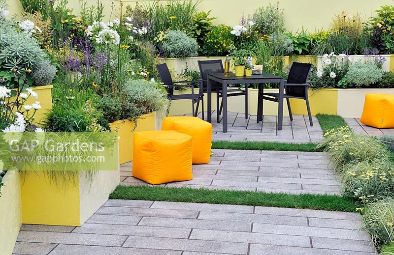 Jardin de patio avec une vaste plantation dans des parterres surélevés peints de couleurs vives - RHS Tatton Park Flower Show