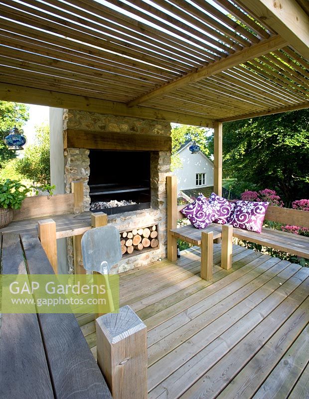 Cuisine extérieure avec terrasse en bois, four et bancs - Jardin de Clare Matthew, Devon