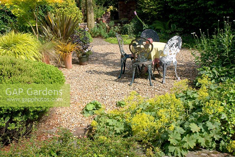 Table et chaises décoratives en métal dans le jardin de gravier d'été à 'Hazelwood', Jacqueline Iddon Hardy Plants, jardin NGS, Lancashire