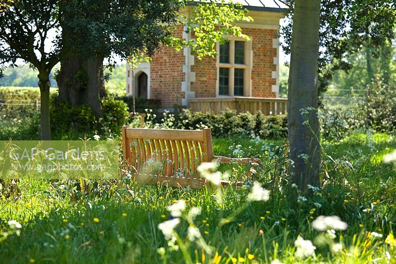 Pré et banc en bois dans les hautes herbes. Jardin de Hatfield House, mai 2008, Royaume-Uni