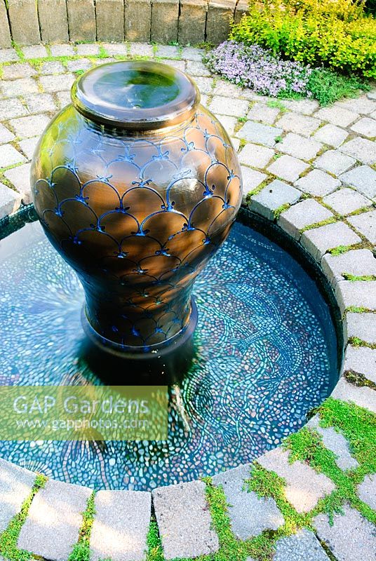 Jeu d'eau de style marocain en pavé circulaire avec piscine bordée de mosaïque
