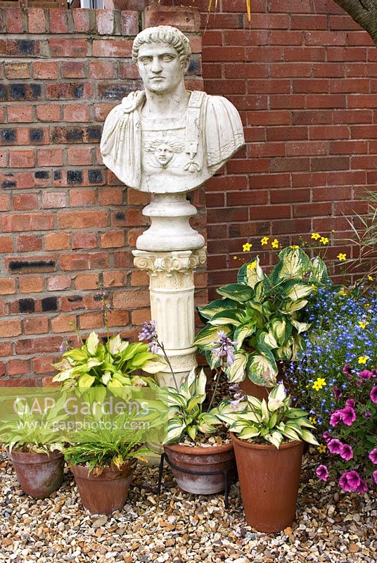 Statue de buste romaine classique sur socle et divers pots en terre cuite avec Hosta. Meadow Ave, Southport, Lancashire. Ouverture du jardin pour le programme des jardins nationaux
