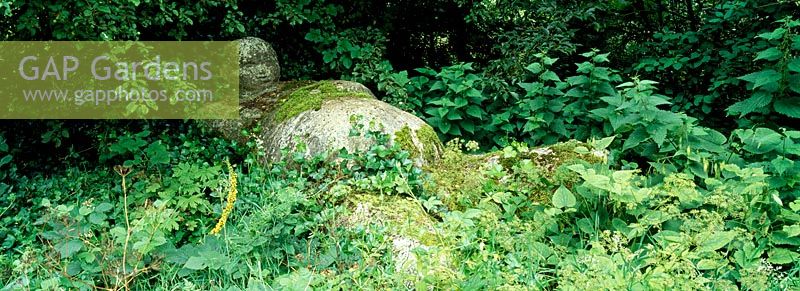 Une figure de pierre couchée dans le jardin sauvage à Priona conçu par Henk Gerritsen, Pays-Bas