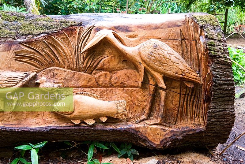 Chêne abattu sculpté de sièges et de scènes d'oiseaux, de poissons et d'animaux par le sculpteur à la tronçonneuse Matthew Crabb. Jardins subtropicaux d'Abbotsbury, Dorset, UK