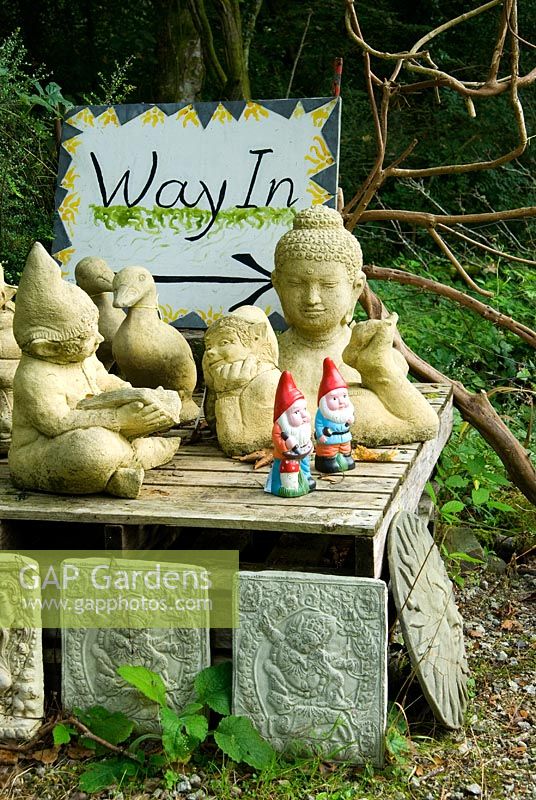 Les plantes dans la zone de vente de la pépinière sont entrecoupées de figures sculpturales, de plaques et de meubles - Pinsla Garden, Cardinham, Cornwall