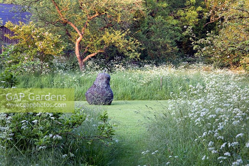 Sculpture 'The World Gone Pear-Shaped' de Deborah sur le pré de fleurs sauvages, entourée d'Anthriscus sylvestris - Cow persil. Maison Cantax, Wiltshire.
