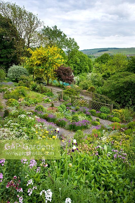 L'aspect en pente orienté au sud du jardin du jardin de Cherry Hill offre une vue dégagée et longue sur la campagne environnante du Derbyshire.