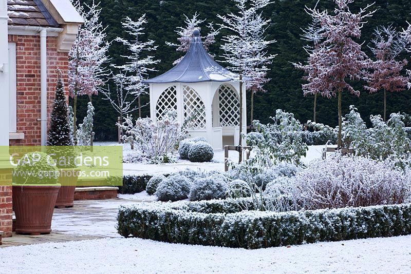 Jardin de ville formelle avec gazebo couvert de neige, Oxford, Royaume-Uni.