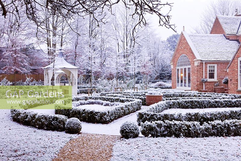 Jardin de ville formel avec gazebo et maison couverte de neige, Oxford, Royaume-Uni.