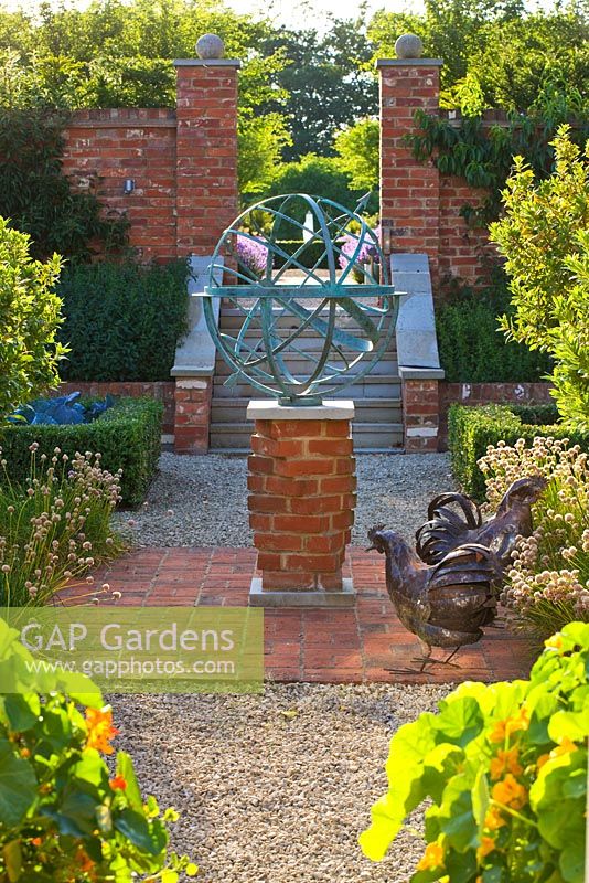 Cadran solaire armillaire en métal et statues de poule sur patio en brique rouge, Oxfordshire