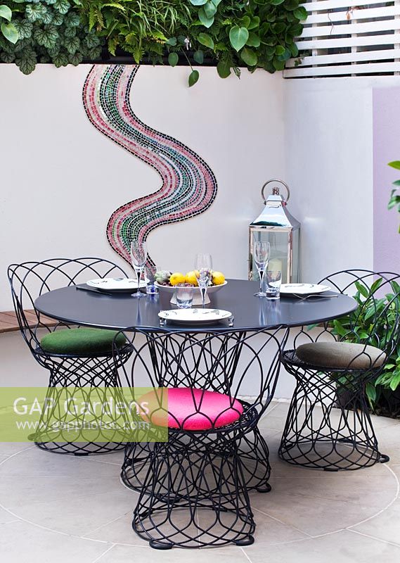 Petit jardin patio avec coin repas et mosaïque par Celia Gregory, Londres.
