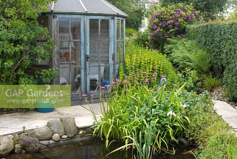 Maison d'été hexagonale en bois dans le jardin du chalet avec étang