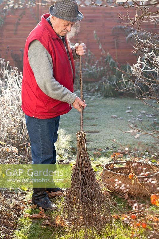 Faire un balai de bouleau - homme ranger les feuilles de la pelouse à l'aide d'une brosse nouvellement créée