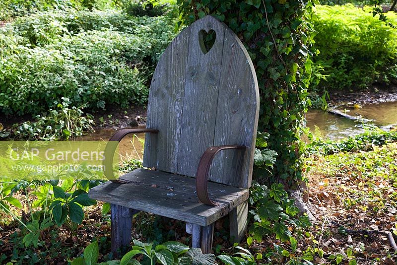 Trône en bois fabriqué par Room dans le jardin, à côté d'un ruisseau dans un jardin boisé sauvage - Le Manoir