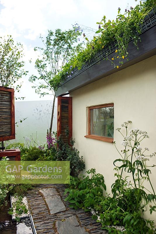 Maison écologique avec toit végétal vert, pavés d'ardoise, plantes indigènes et écrans mobiles pour arrêter les dommages causés par le vent - SAC Strutt et Parker Sustainable Highland Garden, SGS 2010