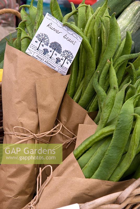 Des paquets de haricots verts sur l'étal du marché