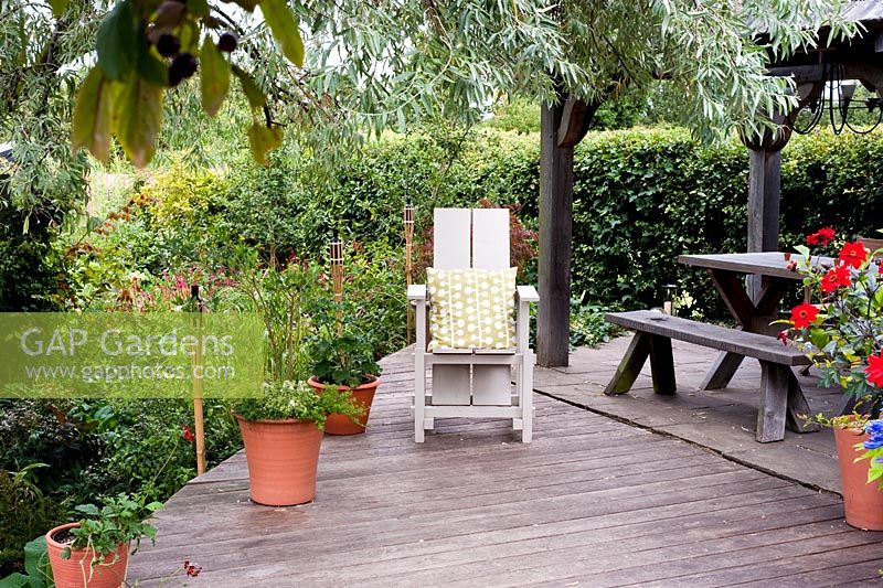 Terrasse en bois surélevé avec chaise adirondack, pots et bougies - Brook Hall Cottages, Essex NGS