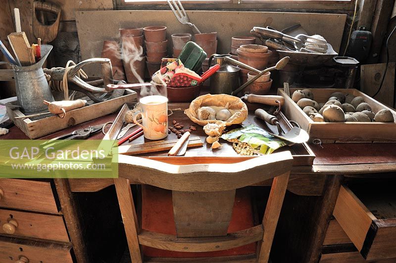 Bureau de remise en pot avec tasse de café fumant, graines, outils de jardinage, mars
