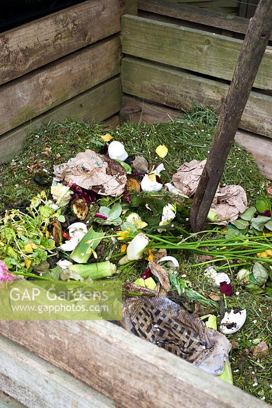 Bac à compost en bois montrant les déchets ménagers et les coupures d'herbe