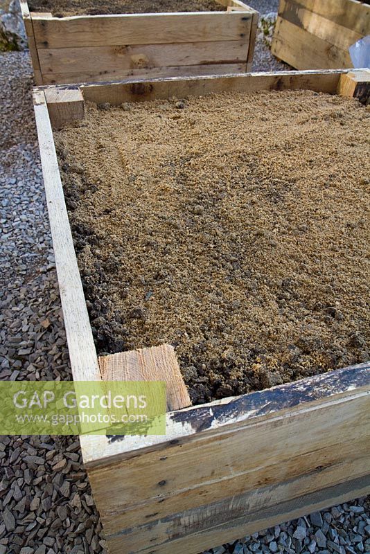 Boîte en chêne remplie d'un mélange de terre, de sable tranchant et de grains fins à utiliser comme bordure végétale surélevée