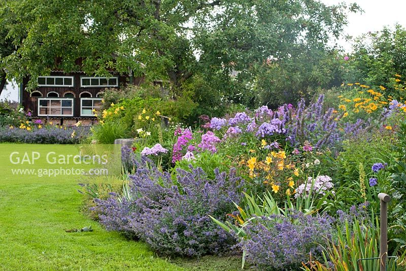 Jardin de campagne bavarois avec abeille et parterre de fleurs vivaces