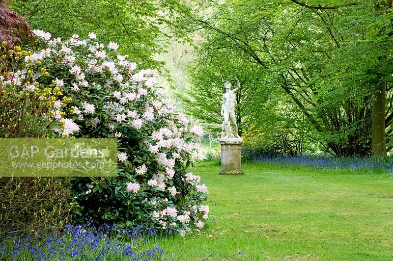 Statue en pierre dans un jardin boisé, printemps