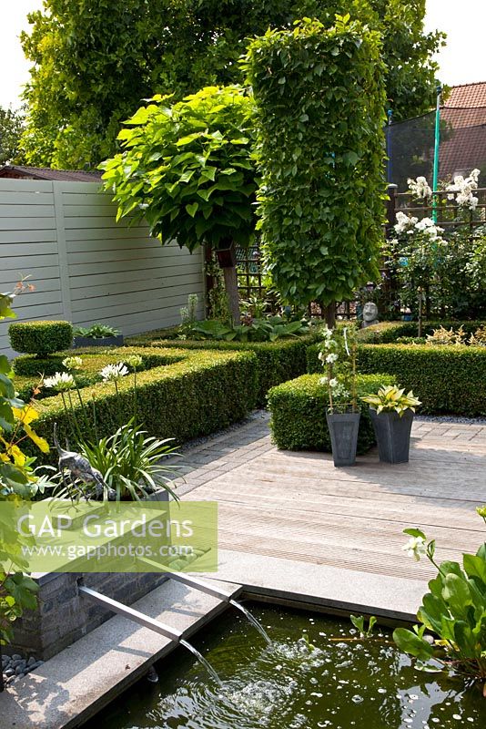 Petit jardin avec plan d'eau et terrasse en bois